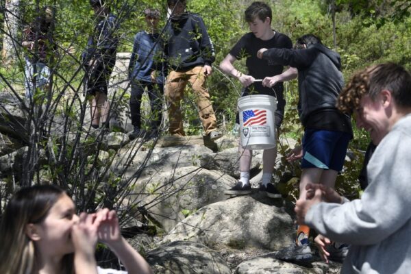 GARDINER, ME - APRIL 18 Gardiner Area High School students carry Wednesday May 18, 2022 buckets of alewife over a dam on Cobbossee Stream in Gardiner. The students captured, studied and released the fish above the impediment. (Staff photo by Andy Molloy/Staff Photographer)