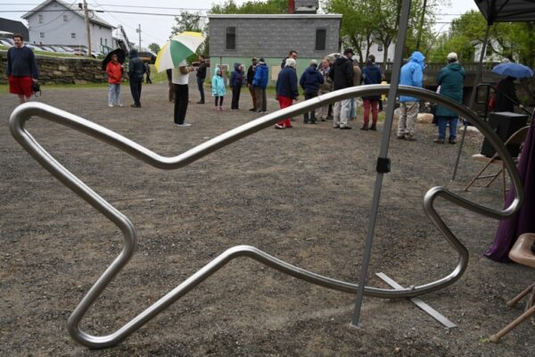 18753# 01alewives VASSALBORO, MAINE May 19, 2022. A fish sculpture is displayed as people gather at a completed Denil fishway during an event that celebrated the project completion along Outlet Stream that flows past the Olde Mill Place at 934 Main St. in Vassalboro, Maine Thursday May 19, 2022. The event, hosted by Maine Rivers, featured a ribbon cutting by Maine Governor Janet Mills. The completed project clears the migration path up China Lake Outlet Stream for the alewives. The project is designed to restore river access and encourage the return of the alewives. (Morning Sentinel/Rich Abrahamson)